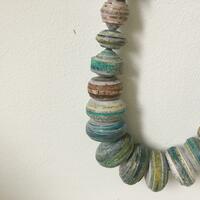Paper beads. Constructed from long strips of painted paper and tightly bound to produce a bead. 