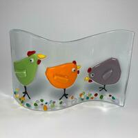 Green, orange and purple chickens on a clear glass background