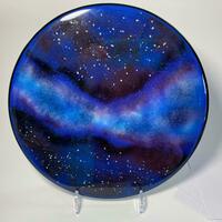 Circular glass panel depicting a galaxy in blue and black 