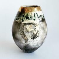Smoke-fired pot with gold lustre.