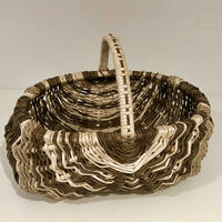Small oval frame basket with delicately skeinned handle. Woven in Warwickshire willow by Clare Shilvock. Dicky Meadows and hand-stripped white willow with natural sea grass accents