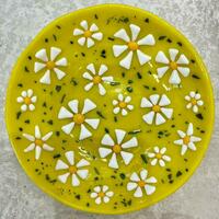 Yellow fused glass medium sized bowl decorated with white flowers and aventureine green glass for shimmer. 
