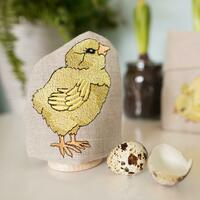 Embroidered egg cosy featuring a little chick with wooden egg cup by Kate Sproston Design