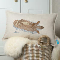 Embroidered linen cushion featuring a mother otter and her pup by Kate Sproston Design