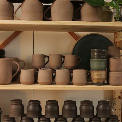 Studio shelves full of freshly trimmed pottery.