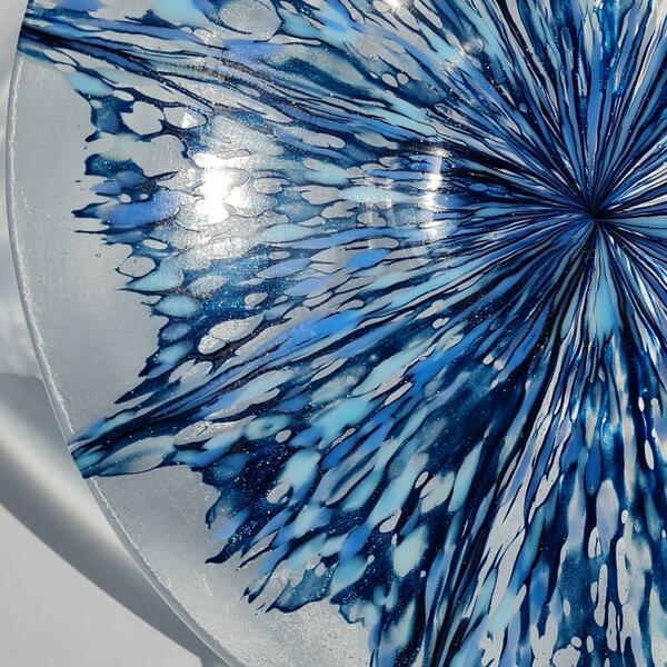 Detail of a large fused glass bowl with multiple explosive shades of blue.