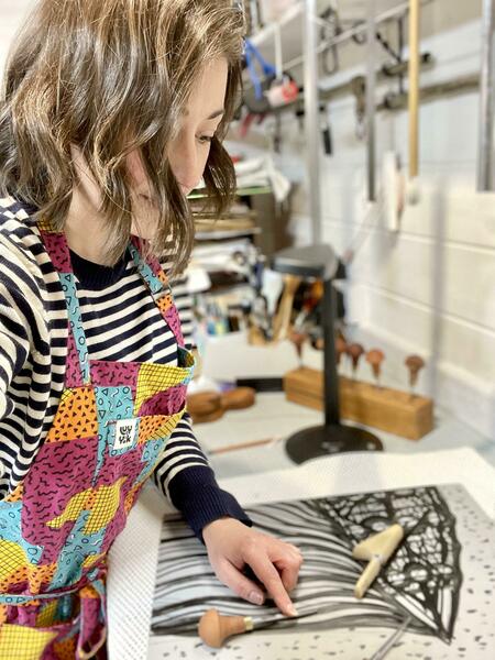 Hayley Burgess in her garden Studio carving a Linoleum Block