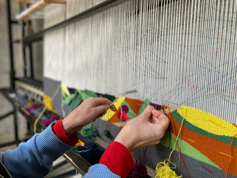 Hand weaving a tapestry