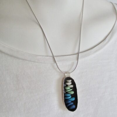 Raised sterling silver 'cocoon' form with stained porcelain micro mosaic cairn